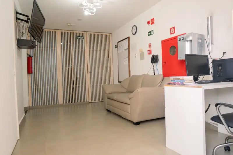 Sala de acolhimento com sofá e estação de trabalho da equipe