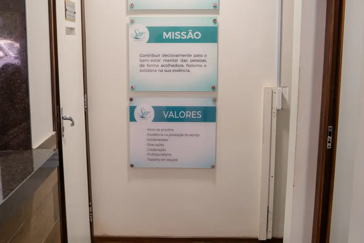 Corredor interno com os painéis de visão, missão e valores da clínica