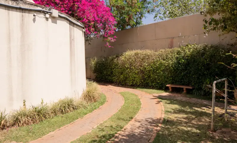 Caminho de tijolos que atravessa o gramado do jardim