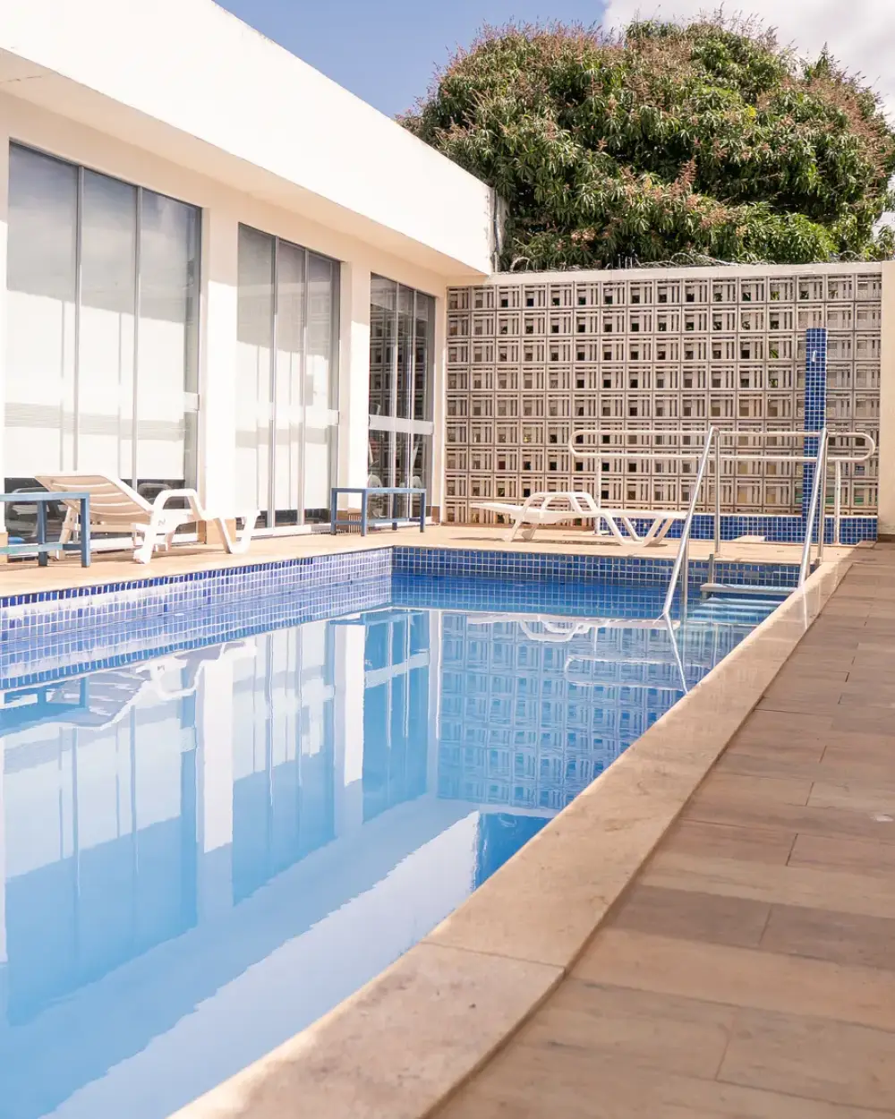 Deck de madeira ao longo da piscina, com espreguiçadeiras