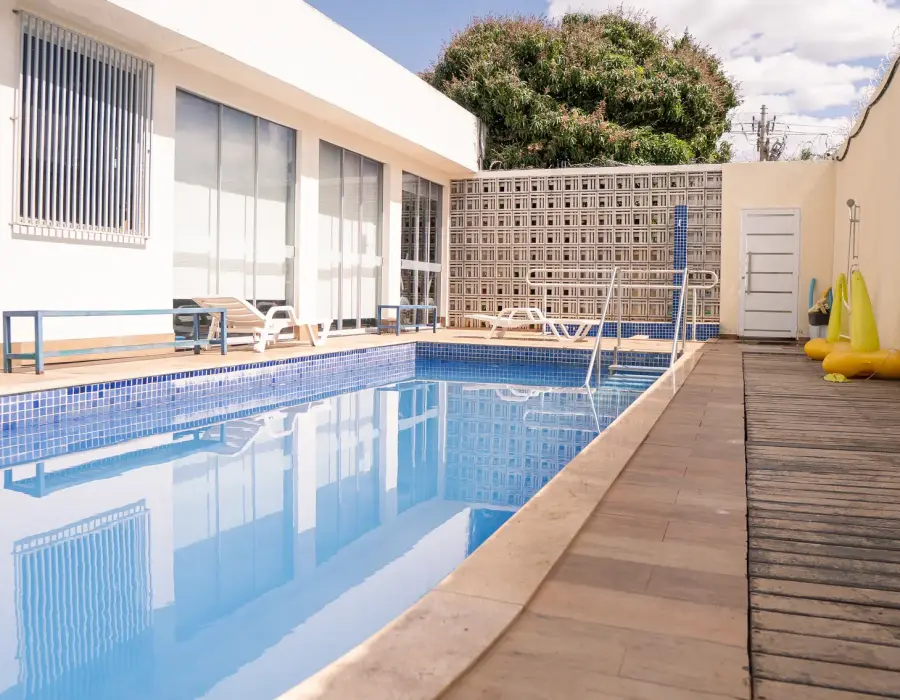 Deck de madeira ao longo da piscina, com espreguiçadeiras